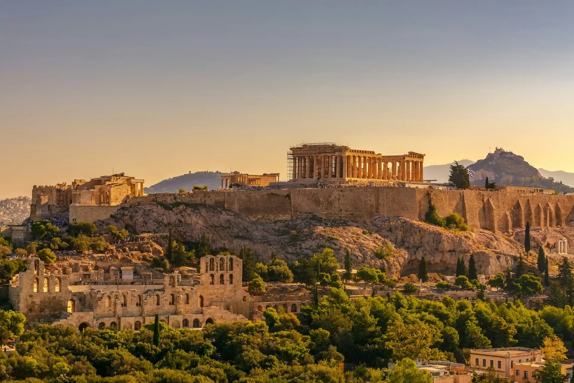 La Acrópolis con el Partenón al atardecer dorado en Atenas