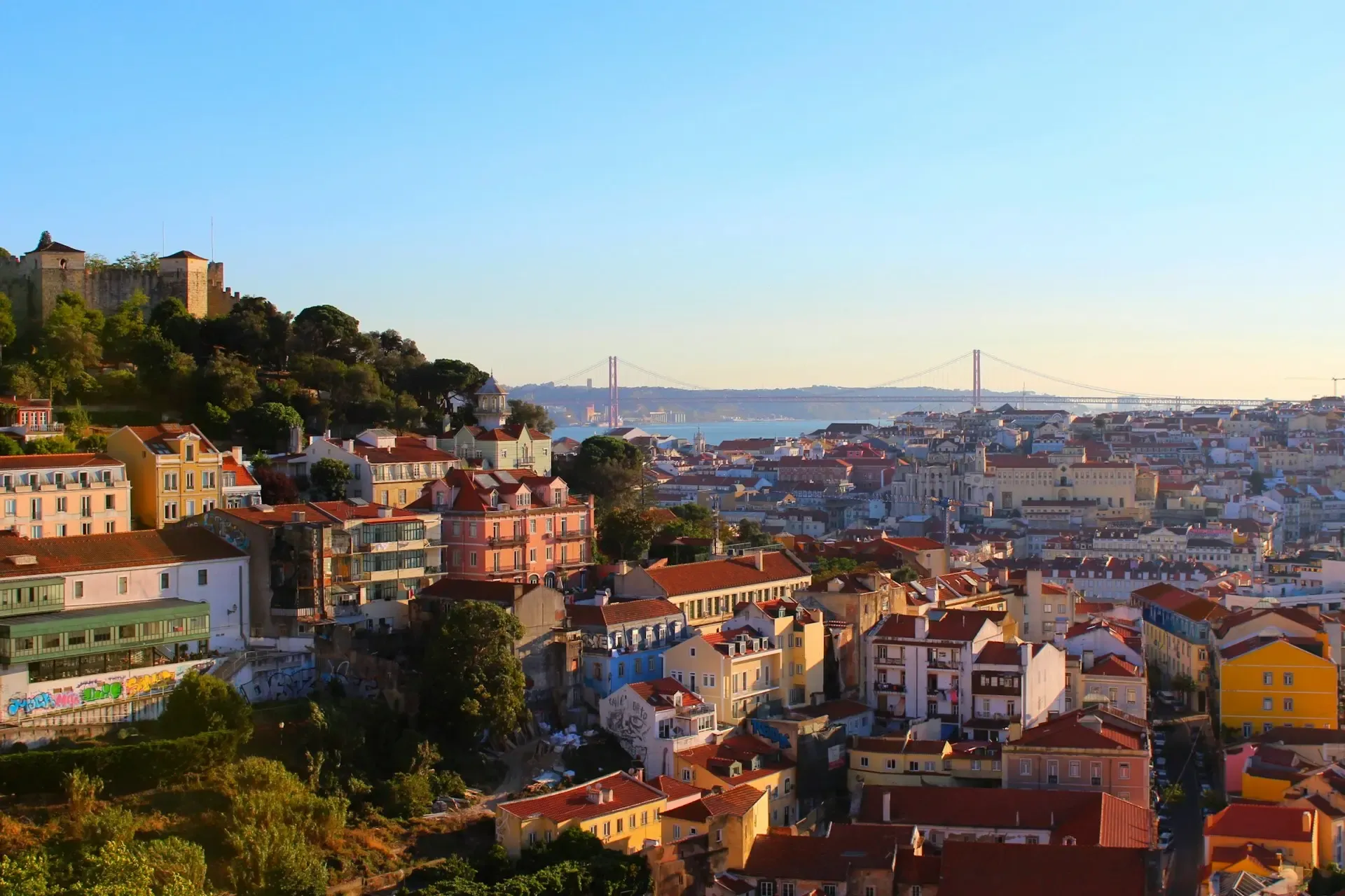 El Castillo de San Jorge sobre los tejados de Lisboa con el puente 25 de Abril al fondo