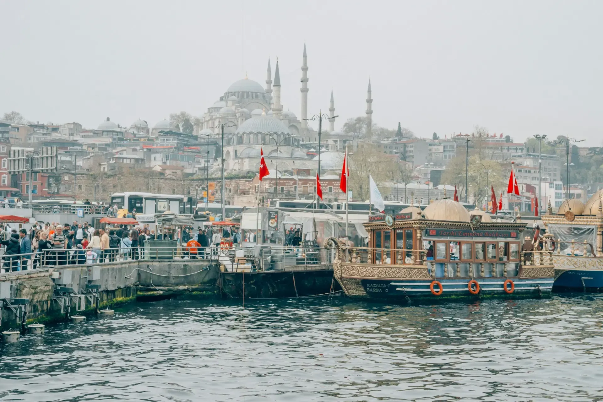 Barcas tradicionales turcas amarradas en el Cuerno de Oro con la Mezquita de Solimán al fondo, Estambul