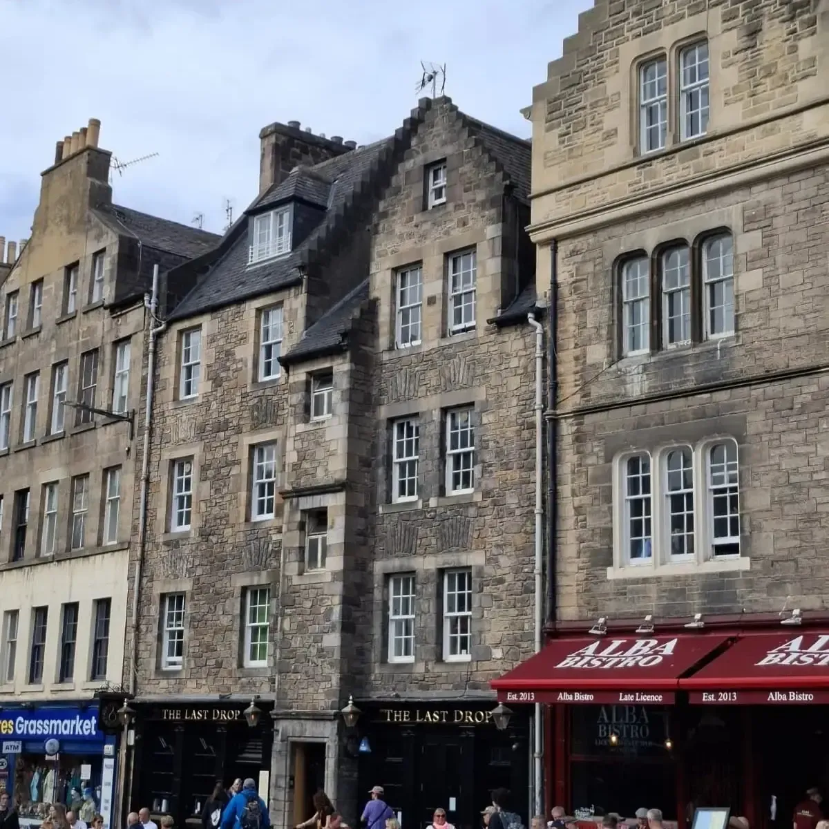 Fachadas de piedra en el Grassmarket de Edimburgo, con el pub The Last Drop y el restaurante Alba Bistro