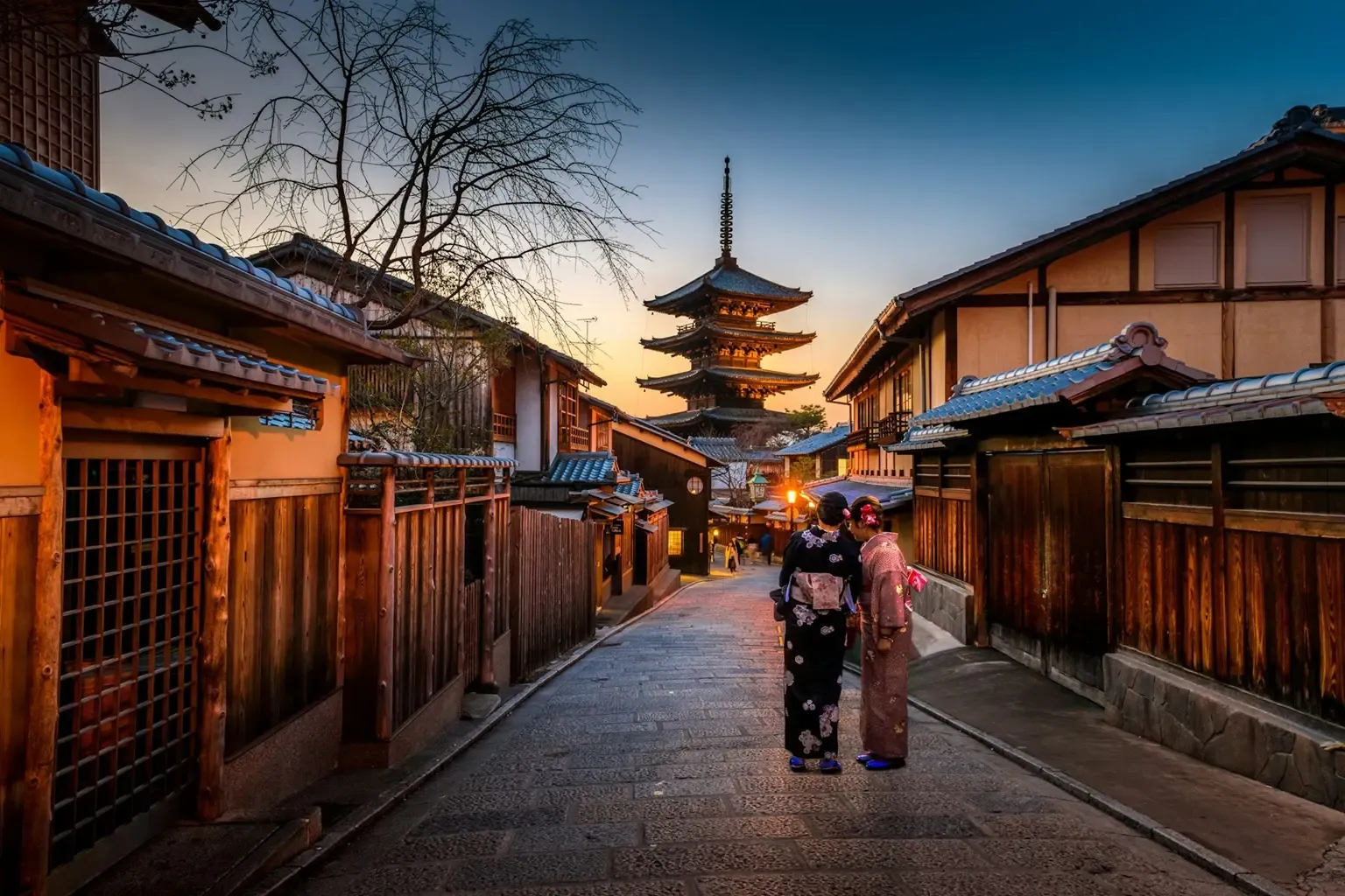 Calle tradicional de Higashiyama con la pagoda Yasaka y dos mujeres en kimono al atardecer, Kioto