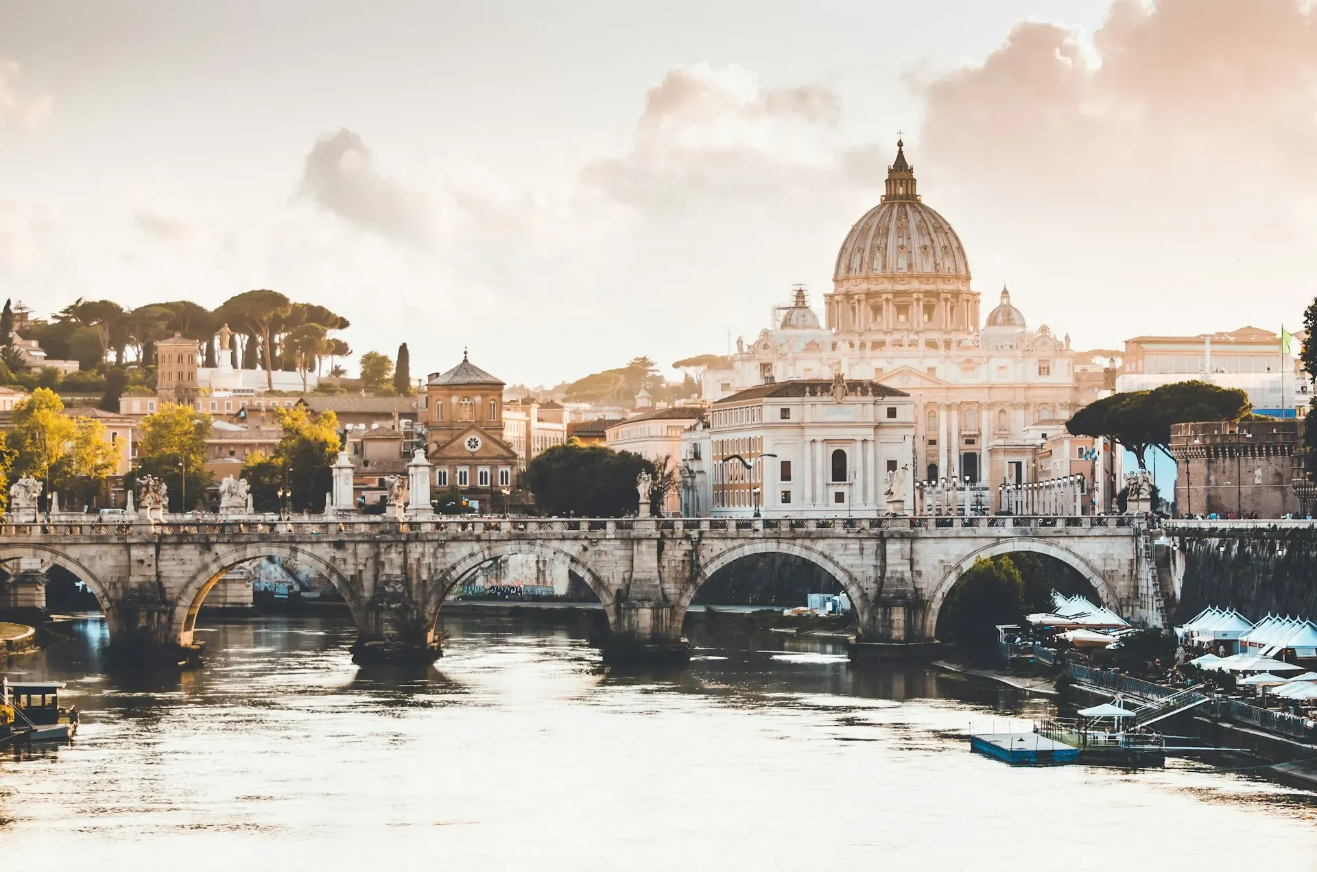 La basílica de San Pedro y un puente sobre el río Tíber al atardecer en Roma